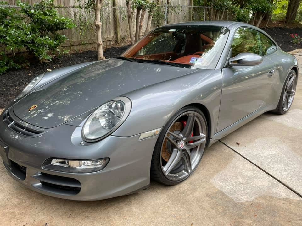 Microfiber towel buffing wax on a glossy car panel for a deep shine